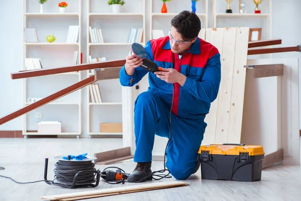 Joven carpintero trabajando con tablones de madera — Foto de Stock