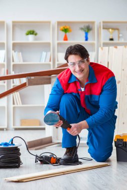 Genç marangoz ahşap kalaslarla çalışıyor.