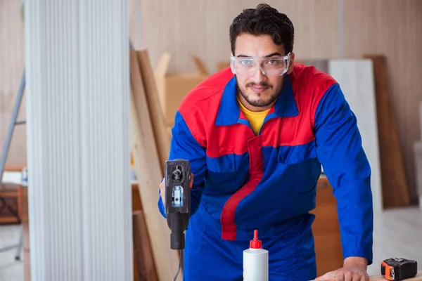 Junger Reparateur arbeitet mit Motorsäge — Stockfoto