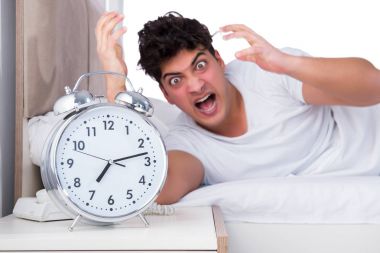 Yatakta uykusuzluk çeken bir adam.