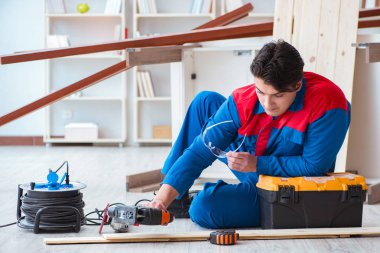 Genç marangoz ahşap kalaslarla çalışmaya ara veriyor.