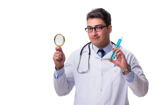 Young doctor with a magnifying glass and a syringe isolated on w — Stock Photo, Image