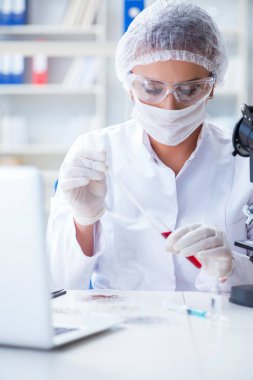 Bir laboratuarda deney yapan kadın bir bilim adamı.