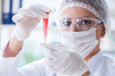 Bir laboratuarda deney yapan kadın bir bilim adamı.