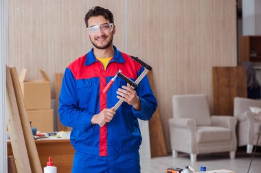 Klemplerle çalışan genç bir tamirci.