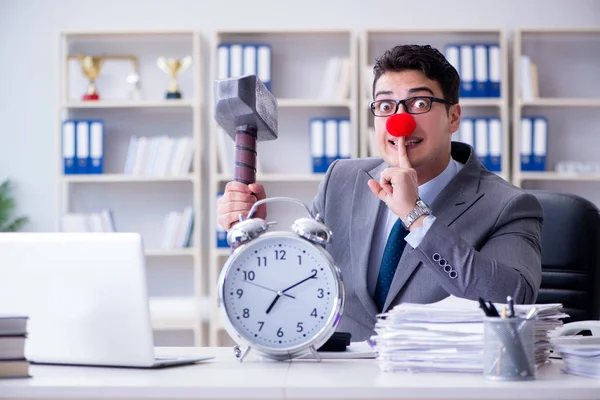 Homme d'affaires clown dans le bureau avec marteau et réveil — Photo