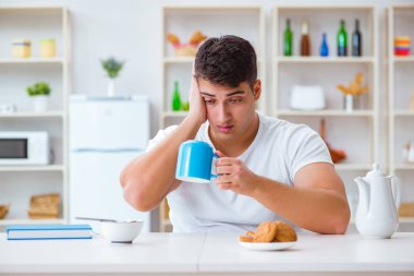 Fazla mesai sonrası kahvaltıda uyuyan bir adam.