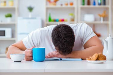 Fazla mesai sonrası kahvaltıda uyuyan bir adam.