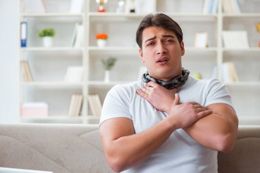 Genç adam boğaz ağrısı çekiyor.