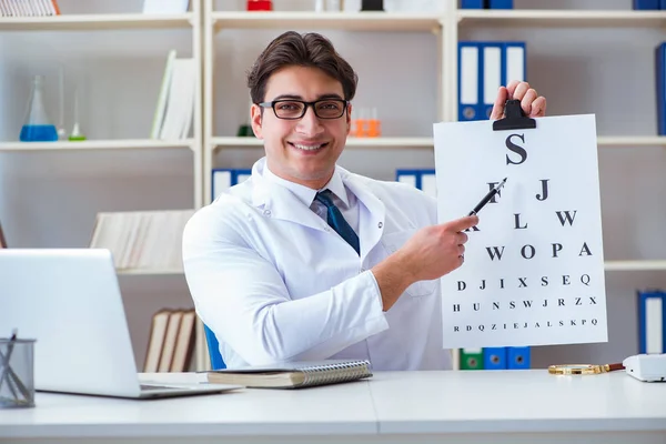 Lekarz optyk z wykresem literowym przeprowadzający badanie wzroku — Zdjęcie stockowe