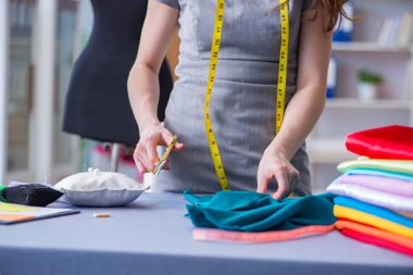 Kadın terzi dikiş dikmek için dikiş dikiyor.