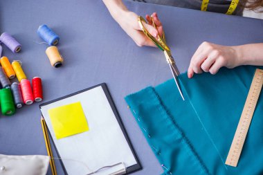 Kadın terzi dikiş dikmek için dikiş dikiyor.