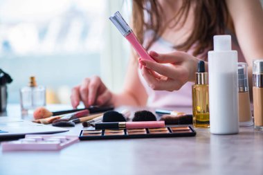 Güzellik konseptinde makyaj malzemeleri olan bir kadın.