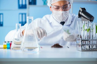 Erkek bilim adamı bir laboratuarda deney yapıyor.