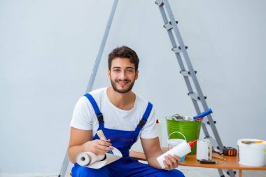 Tamirci, duvar kağıdıyla evde tadilat yapıyor.