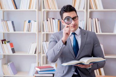 Büyüteçle hukuk fakültesi öğrencisi kitap okuyor.