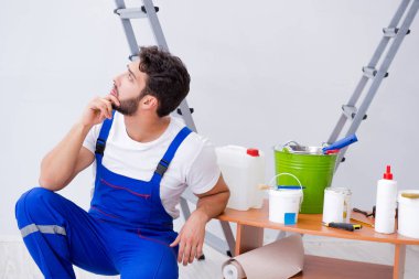 Tamirci, duvar kağıdıyla evde tadilat yapıyor.