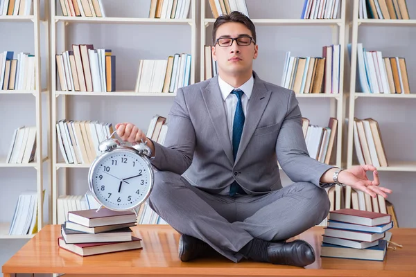 Affärsman student i lotusställning med en väckarklocka i lib — Stockfoto