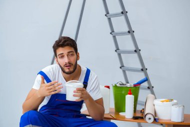 Tamirci, duvar kağıdıyla evde tadilat yapıyor.