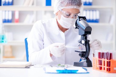 Bir laboratuarda deney yapan kadın bir bilim adamı.