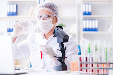 Bir laboratuarda deney yapan kadın bir bilim adamı.