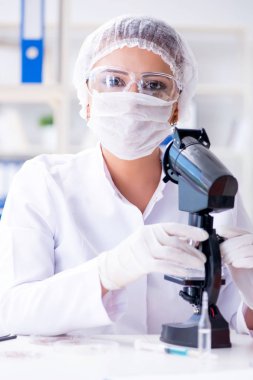 Bir laboratuarda deney yapan kadın bir bilim adamı.