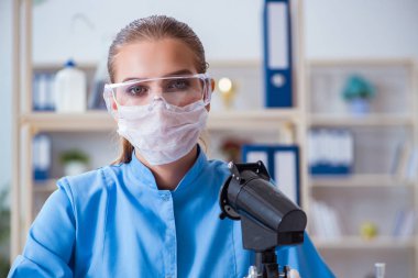 Bir laboratuarda deney yapan kadın bir bilim adamı.