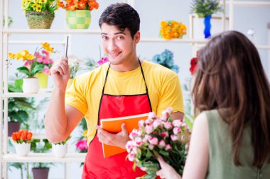 Çiçekçi dükkanında çiçek satıyor.