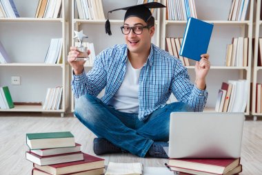 Genç öğrenci kitaplarla çalışıyor.