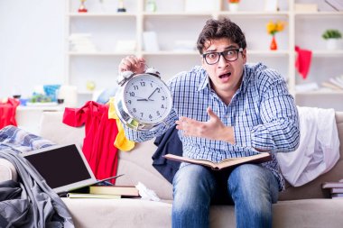 Genç adam dağınık bir odada çalışıyor.
