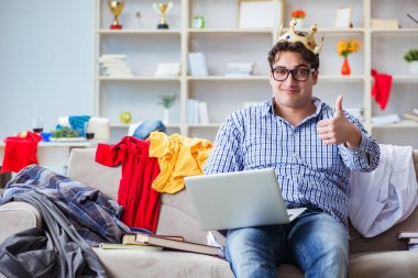 Genç adam dağınık bir odada çalışıyor.