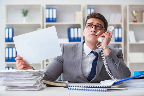 Empresário fumando no trabalho no escritório segurando uma mensagem em branco bo — Fotografia de Stock