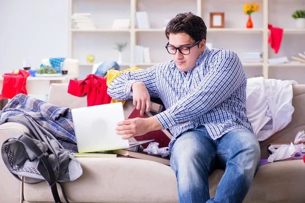 Joven trabajando estudiando en una habitación desordenada — Foto de Stock