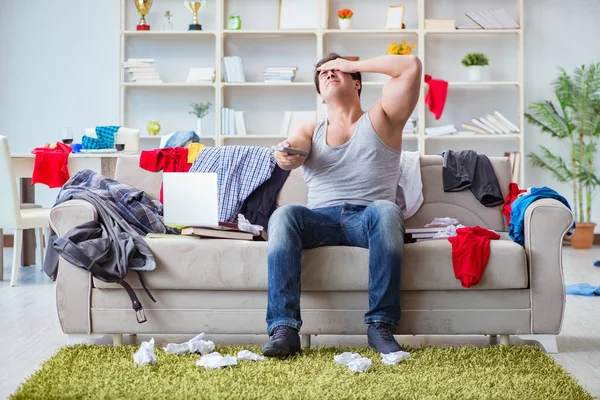 Joven trabajando estudiando en una habitación desordenada — Foto de Stock