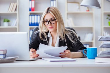 Ofisteki masada dizüstü bilgisayarda çalışan iş kadını.