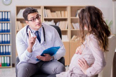 Hamile kadın muayene için doktoru ziyaret ediyor.