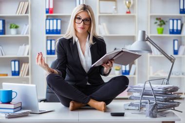 İş kadını ofiste meditasyon yaparken hayal kırıklığına uğradı