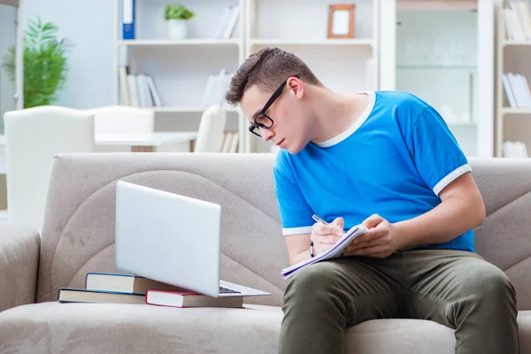 Jovem estudante se preparando para exames estudando em casa em um sofá — Fotografia de Stock