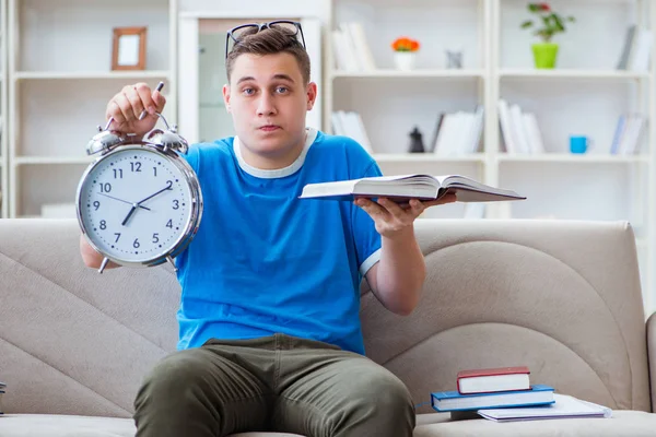 Sınavlara hazırlanan genç öğrenci kanepede ders çalışıyor.