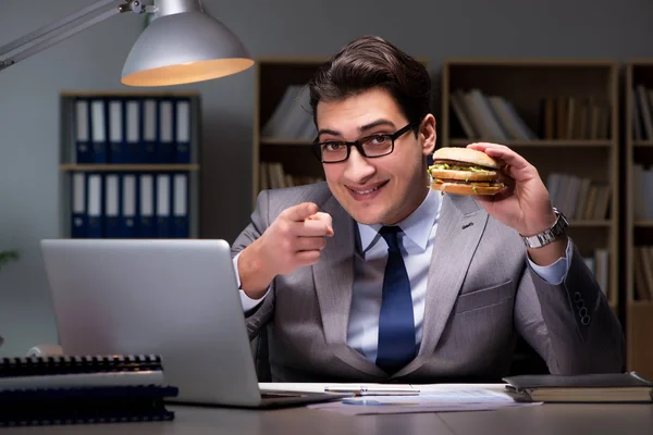 Geschäftsmann spät in der Nacht einen Burger essen — Stockfoto