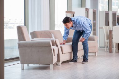 Genç adam mobilya dükkanından alışveriş yapıyor.