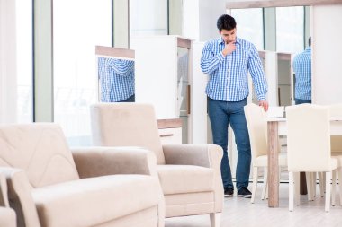 Genç adam mobilya dükkanından alışveriş yapıyor.