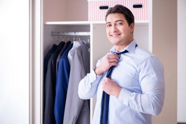 Genç işadamı iş için giyiniyor.