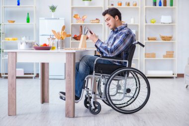 Engelli genç koca mutfakta çalışıyor.