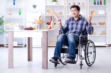 Engelli genç koca mutfakta çalışıyor.