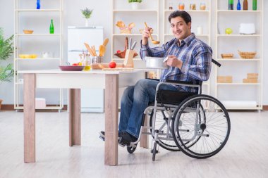 Engelli adam mutfakta çorba hazırlıyor.