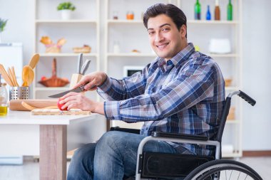 Genç engelli koca yemek salatası hazırlıyor.