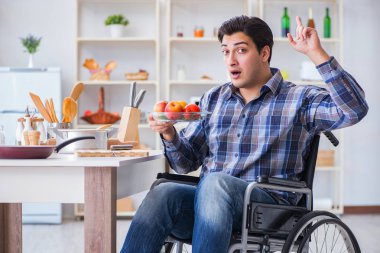 Genç engelli koca yemek salatası hazırlıyor.