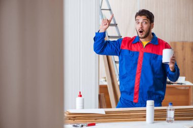 Yooung marangoz boyayla uğraşıyor.