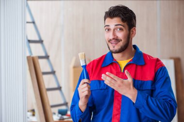 Yooung marangoz boyayla uğraşıyor.